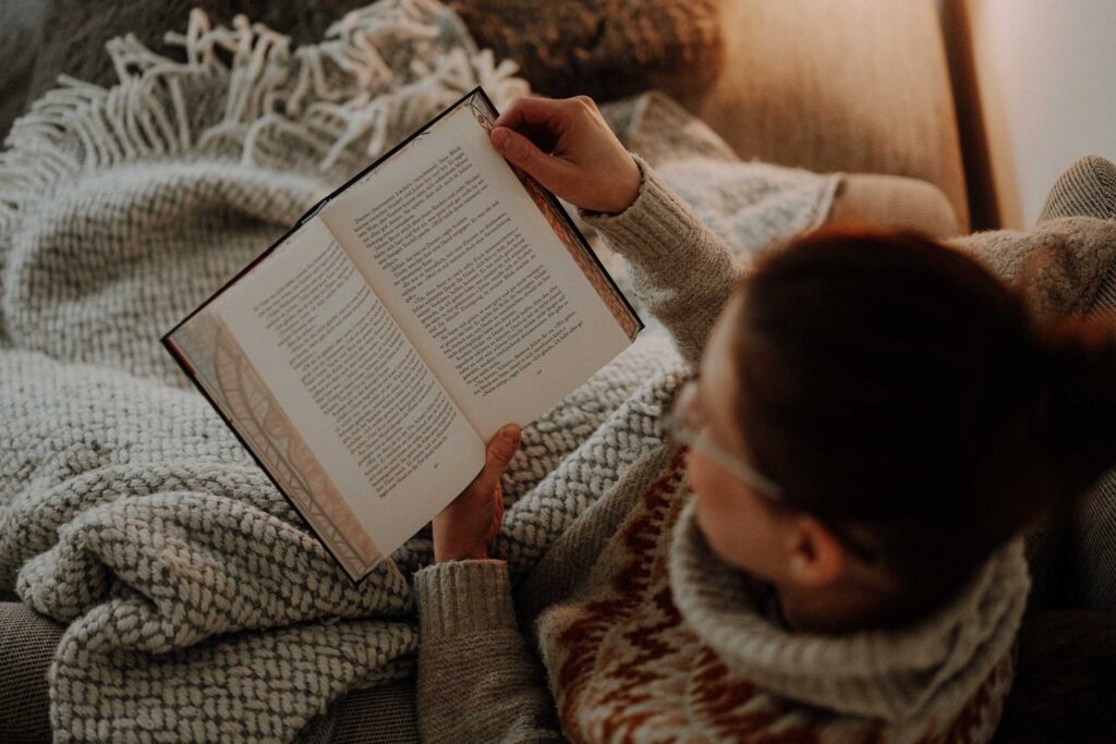 Simone Schuh von vlygge Living liest gemütlich auf Couch – Hygge-Momente für vegane Pionierinnen